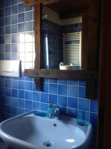 Baño de azulejos azules con lavabo y espejo en Baita Plagnol Sestriere Ski Slopes, en Sestriere