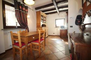 een keuken met een houten tafel en stoelen in een kamer bij Baita Plagnol Sestriere Ski Slopes in Sestriere