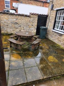 a picnic table sitting on a patio in the rain at The New Inn in Thornton Dale