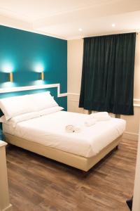 - une chambre avec un grand lit et un mur vert dans l'établissement Le Petit Bijou, à Rome