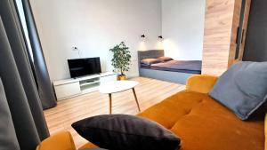 a living room with a couch and a bed at Mano erdvės in Anykščiai