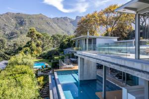 an aerial view of a house with a swimming pool and mountains at Southdown Masterpiece with backup power in Cape Town