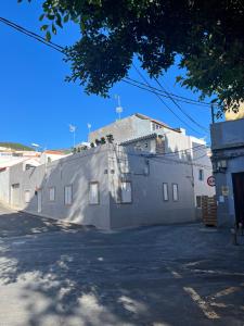 un edificio blanco con una cruz a su lado en Studio Plaza Molino del Gofio Only Adults, en Granadilla de Abona