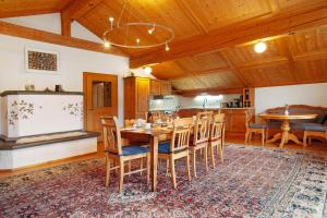 Il comprend une cuisine et une salle à manger avec une table et des chaises en bois. dans l'établissement Ferienwohnung Caprano, à Sonthofen