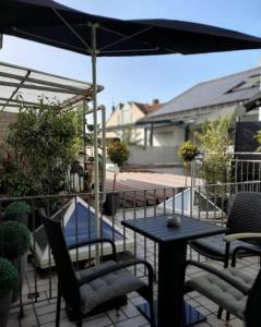 een patio met een tafel en stoelen en een parasol bij Stadt Hotel Marktheidenfeld in Marktheidenfeld