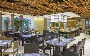 a restaurant with tables and chairs and a bar at Jinling Hotel in Nanjing