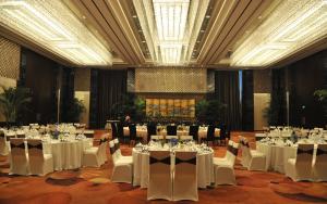 a banquet hall with white tables and chairs at Jinling Hotel in Nanjing