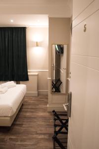 Cette petite chambre comprend un lit et un miroir. dans l'établissement Le Petit Bijou, à Rome