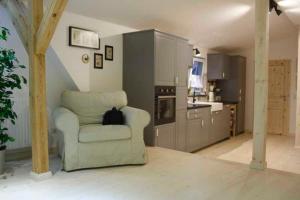 a living room with a chair in a kitchen at Ferienhof Homann in Lindenberg