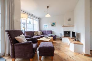 a living room with a couch and a tv at Mine Heimat 15 in Zingst