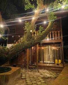 un arbre se penchant sur une maison la nuit dans l'établissement Vilarejo Hospedagem, à Ilha do Mel