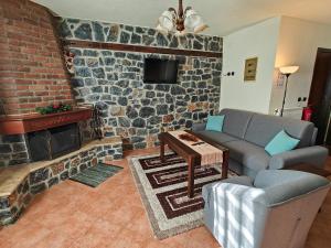 a living room with a couch and a fireplace at Yades Pozar in Kato Loutraki