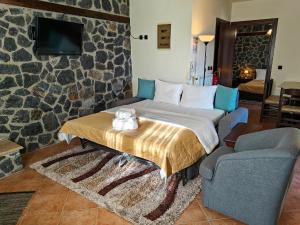 a hotel room with a bed and a couch at Yades Pozar in Kato Loutraki