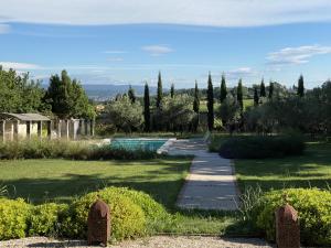 a garden with a path and a swimming pool at Le Domaine de L'Osage in Pont-Saint-Esprit