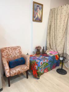 1 dormitorio con silla y 1 cama con manta en ㄧ個背包客棧 en Chu-nan-ts'un