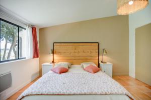 a bedroom with a large bed with two pink pillows at Le Domaine de L'Osage in Pont-Saint-Esprit