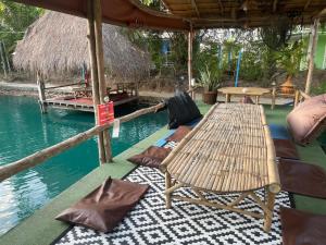 d'une terrasse avec une table et des chaises au bord de l'eau. dans l'établissement บุญพน รีสอร์ต Maldives resort&restaurant, à Wichian Buri