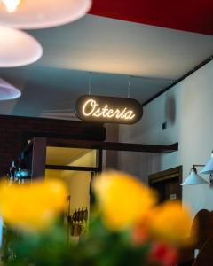 a neon sign hanging from the ceiling of a restaurant at Al Fogolâr Rooms & Osteria with Saunaland in Tolmezzo