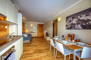 a kitchen and a dining room with a table and chairs at Maison Checrouit in Courmayeur