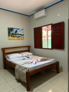 a bedroom with a bed and a window with flowers on it at Imperio dos Bambus Suites in Jijoca de Jericoacoara