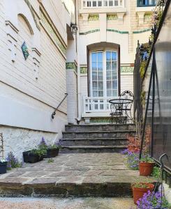 een huis met een patio met een tafel en een raam bij 2 chambres dans une maison proche de Paris et du Stade de France in Enghien-les-Bains