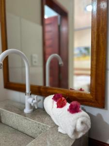 a towel on a sink in front of a mirror at Imperio dos Bambus Suites in Jijoca de Jericoacoara