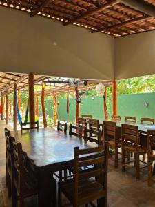 a dining room with a large wooden table and chairs at Imperio dos Bambus Suites in Jijoca de Jericoacoara