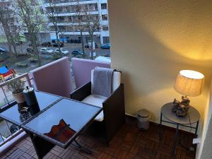 d'un balcon avec une table, une chaise et une lampe. dans l'établissement Appartement Schwetzingerstadt, à Mannheim