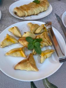 two plates of food on a table with a knife at Pousada & Kitnet Nascer do Sol in Ilha de Boipeba