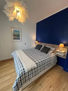ein Schlafzimmer mit einem großen Bett mit blauer Wand in der Unterkunft Appartement Saint-Malo - 10 mètres de la mer in Saint-Malo