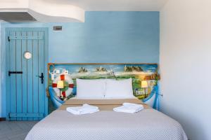 1 dormitorio azul con 1 cama con una pintura en la pared en Espira by Antioch Hotel, en Urla
