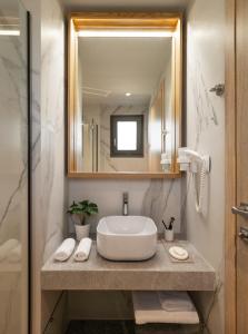 a bathroom with a sink and a mirror at Eco Green Residences & Suites in Toroni