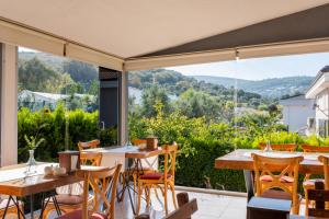 un patio con tavoli, sedie e una grande finestra di Espira by Antioch Hotel a Urla