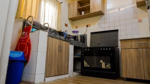 a kitchen with a black oven and wooden cabinets at House 575 in Abuja