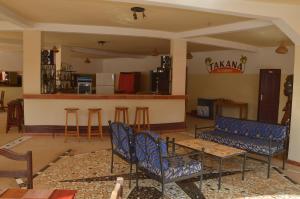 una sala de estar con sillas azules y un bar en Hotel Takana, en Ngaparou
