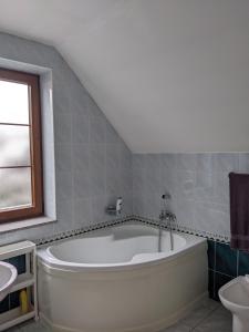a bathroom with a large tub and a sink at INFINITA Bodice in Liptovský Mikuláš +29 photos