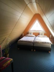 2 łóżka w pokoju na poddaszu z oknem w obiekcie Ferienhaus mit Terrasse - Insel Usedom w Trassenheide