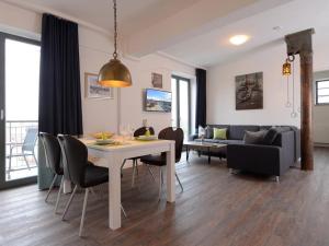 comedor y sala de estar con mesa y sillas en Ohlerich Speicher App_ 24 en Wismar