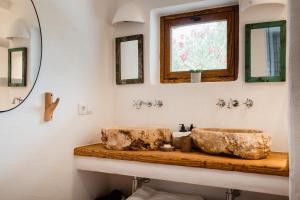 Un baño con dos lavabos y un espejo. en Can Vistabella Boutique Resort, en San Antonio