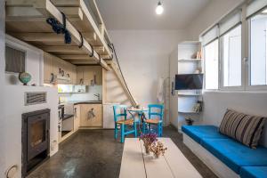 a living room with a blue couch and a table at Γκαρσονιέρα #2 υπνοδωμάτιο σε οντά in Heraklio