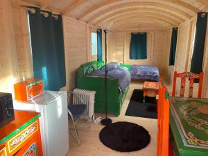 une petite chambre avec deux lits superposés et une cuisine dans l'établissement Le Village Insolite yourte et roulotte, à Saint-Benoît-des-Ondes