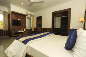 Little Mastiff Pong View في دارامشالا: غرفة نوم بسرير كبير ومخدة زرقاء