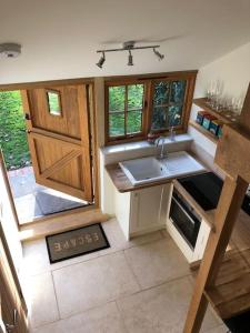 a small kitchen with a sink and a door at The Bike Shed, Near Brill in Aylesbury