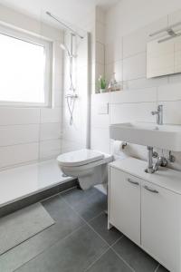 a white bathroom with a toilet and a sink at Ferienwohnug Harzglück in Clausthal-Zellerfeld