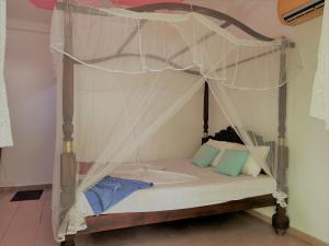 Bett mit Baldachin in einem Zimmer in der Unterkunft La Villa in Unawatuna