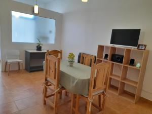 a dining room with a table and chairs and a television at KaVa in Rawson +9 photos