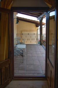 een open deur naar een balkon met een tafel en stoelen bij Hotel Rural Abadía de Yuste in Cuacos de Yuste