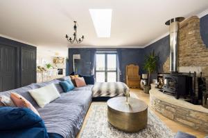 a living room with a couch and a fireplace at Chic Family Barn, edge of Frome + country views in Frome