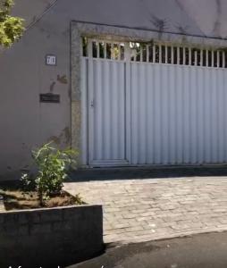 uma cerca branca em frente a um edifício com uma porta em Casa Suakasa Temporada Praia de Itaparica em Vila Velha