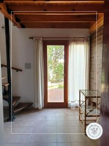 a room with a large glass door with a window at Jarillas del Mar in Las Grutas